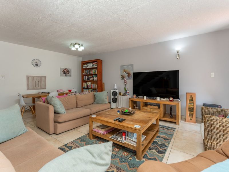 A comfortable living room featuring tiled flooring and neutral wall finishes, providing a functional and inviting space for relaxation.