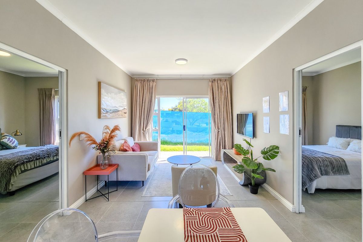 Bright and modern living room featuring large sliding glass doors leading to an outdoor area, neutral tiled flooring, and clean wall finishes.