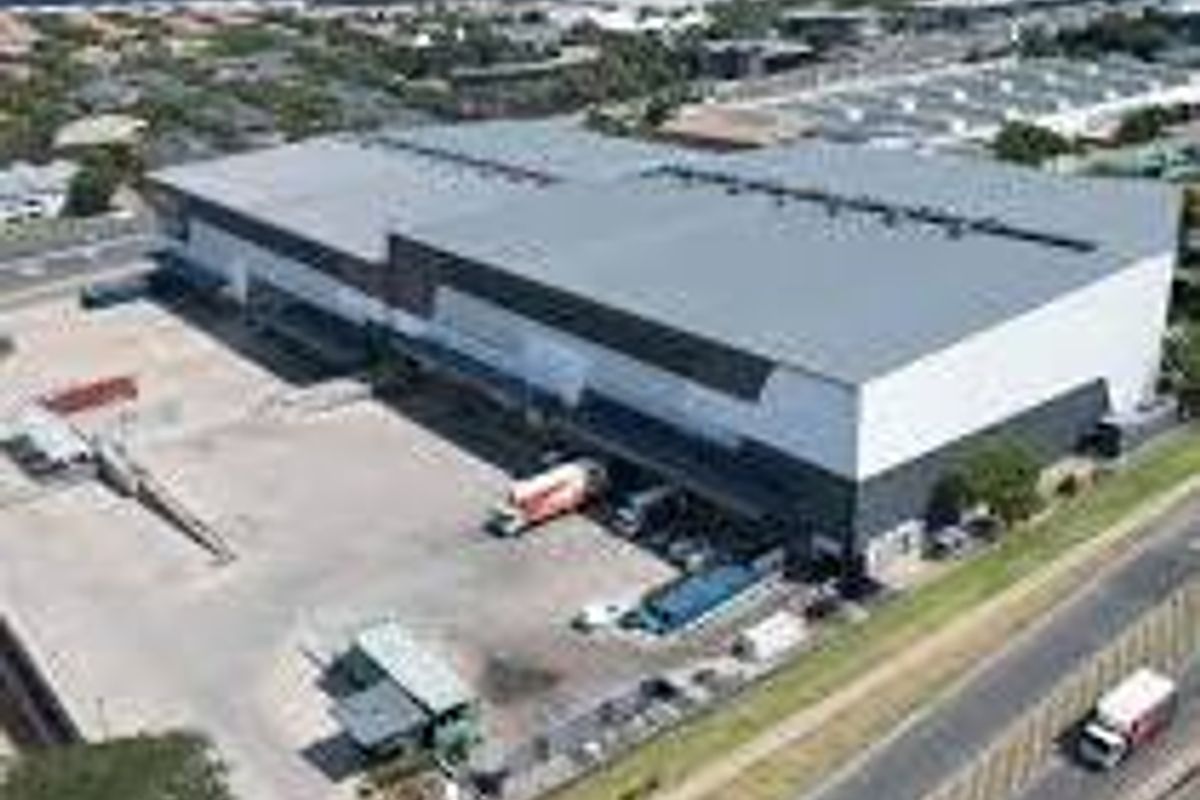 Aerial view of a large industrial warehouse facility featuring extensive loading docks and a paved yard area.