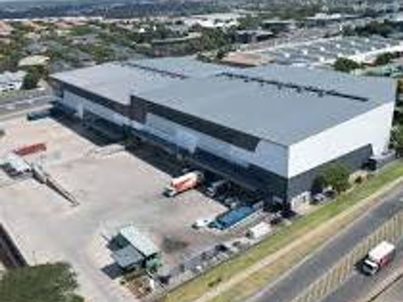 Aerial view of a large industrial warehouse facility featuring extensive loading docks and a paved yard area.