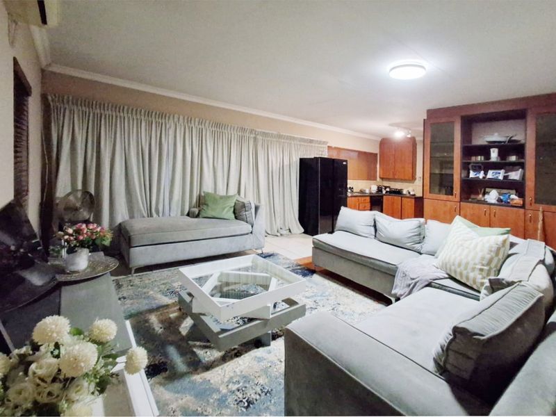 Open plan living area featuring integrated kitchen cabinetry and a spacious lounge layout, providing a functional and connected living space.