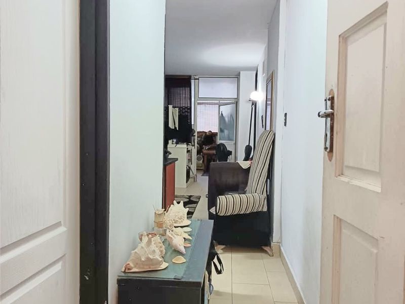 A functional hallway with tiled flooring connecting the entrance to the main living area of the apartment.