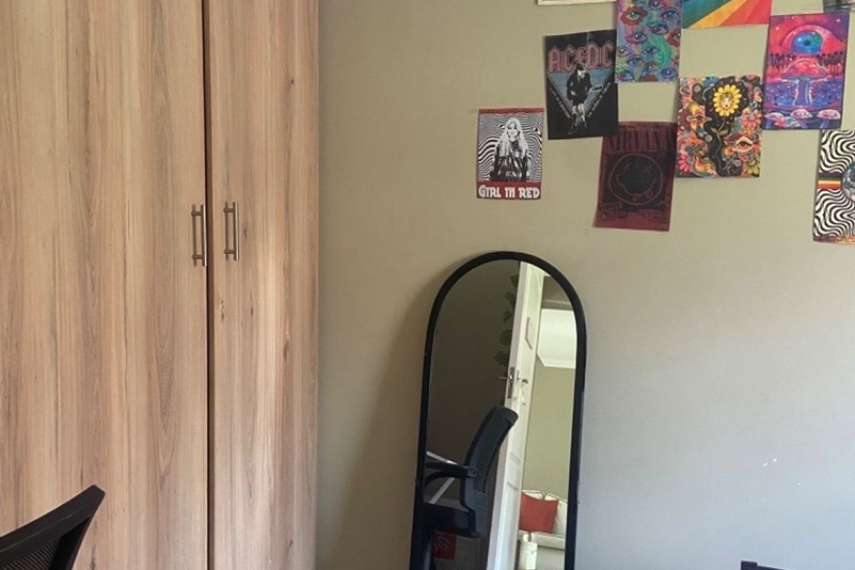 A bedroom featuring built-in wooden cupboards and tiled flooring, providing functional storage space within the room.