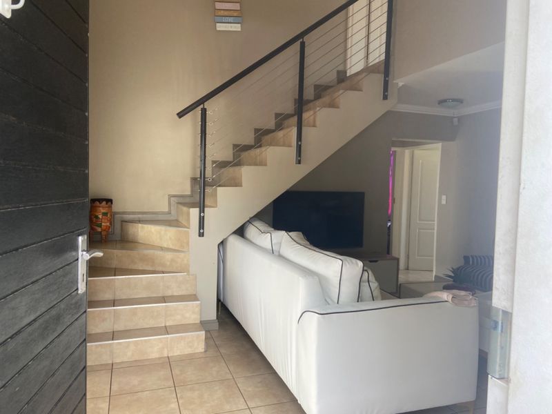 Entrance area featuring a tiled staircase with a modern metal balustrade, leading directly into the main living space of the townhouse.