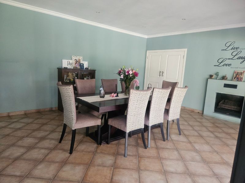 Spacious dining room featuring tiled flooring, a built-in fireplace, and recessed lighting, offering a comfortable area for family meals and entertaining.