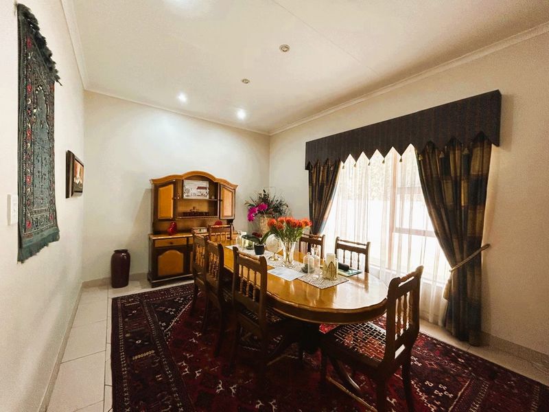 A well-maintained dining room featuring tiled flooring, recessed downlighting, and decorative cornicing, providing a formal space for family meals and entertaining.