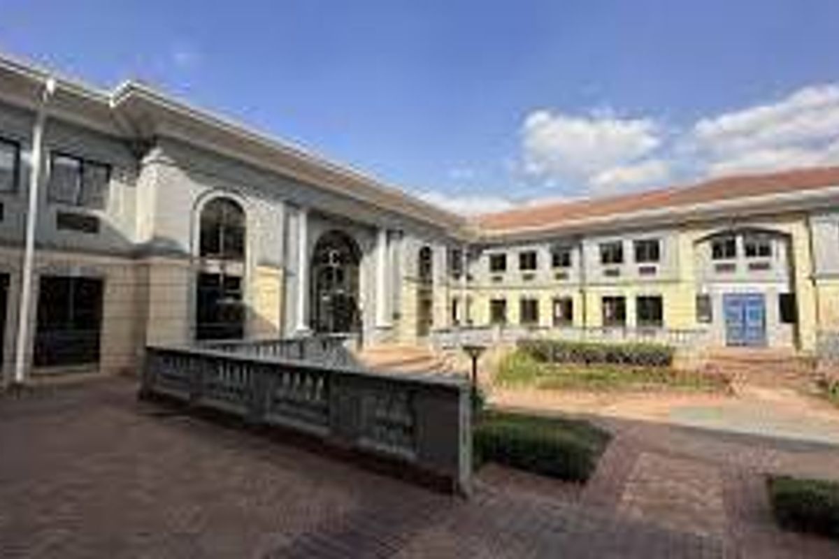 A view of the commercial property's rear courtyard featuring paved walkways, balustrades, and multi-story building facades with arched architectural details.