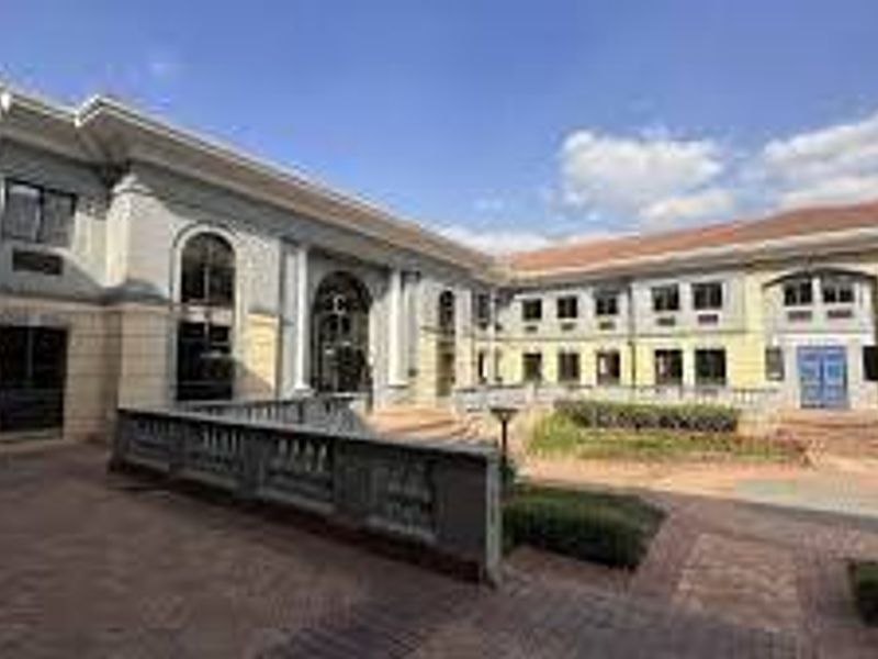 A view of the commercial property's rear courtyard featuring paved walkways, balustrades, and multi-story building facades with arched architectural details.