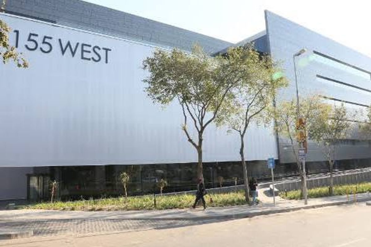 Modern commercial office building facade featuring sleek metal cladding and prominent street-level signage at 155 West.