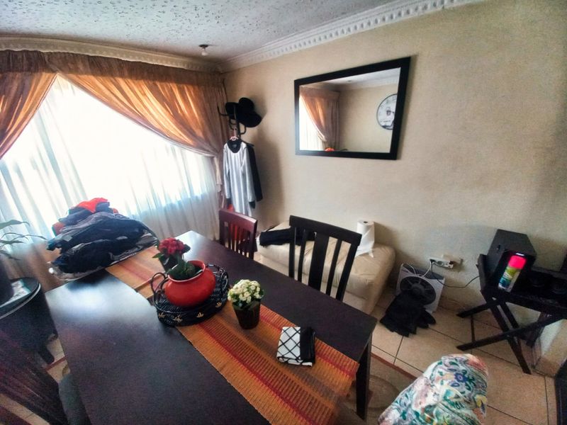 Dining room featuring tiled flooring and decorative ceiling cornicing, offering a functional space for family meals.