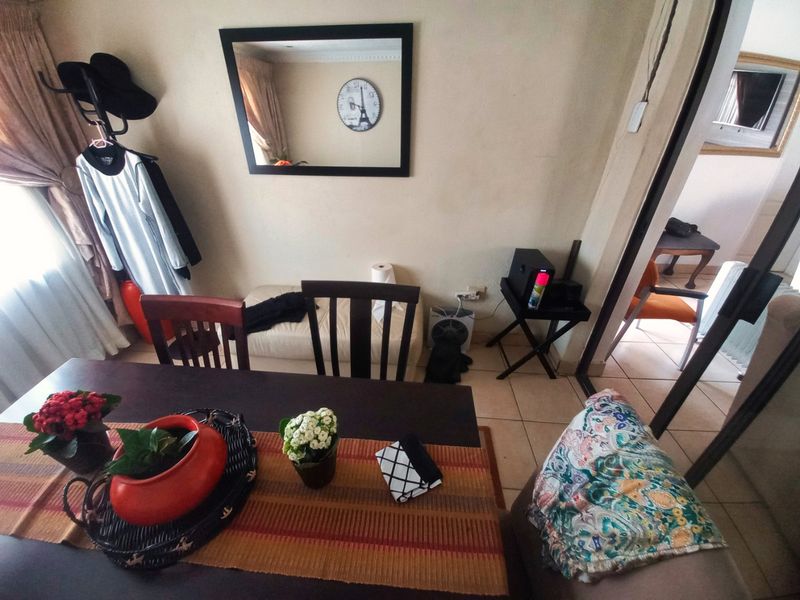 A dining area featuring tiled flooring and coving, providing a functional space for meals with access to an adjacent room.