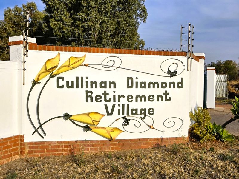 The entrance signage and boundary wall for the Cullinan Diamond Retirement Village, featuring brick detailing and security electric fencing.