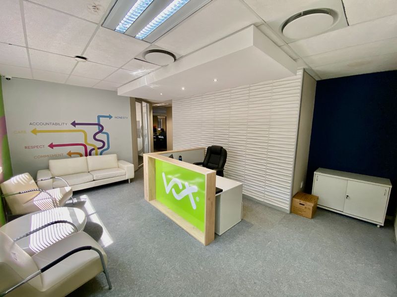 Commercial reception area featuring a branded desk, textured feature wall, and integrated storage, providing a professional welcome space for clients and visitors.