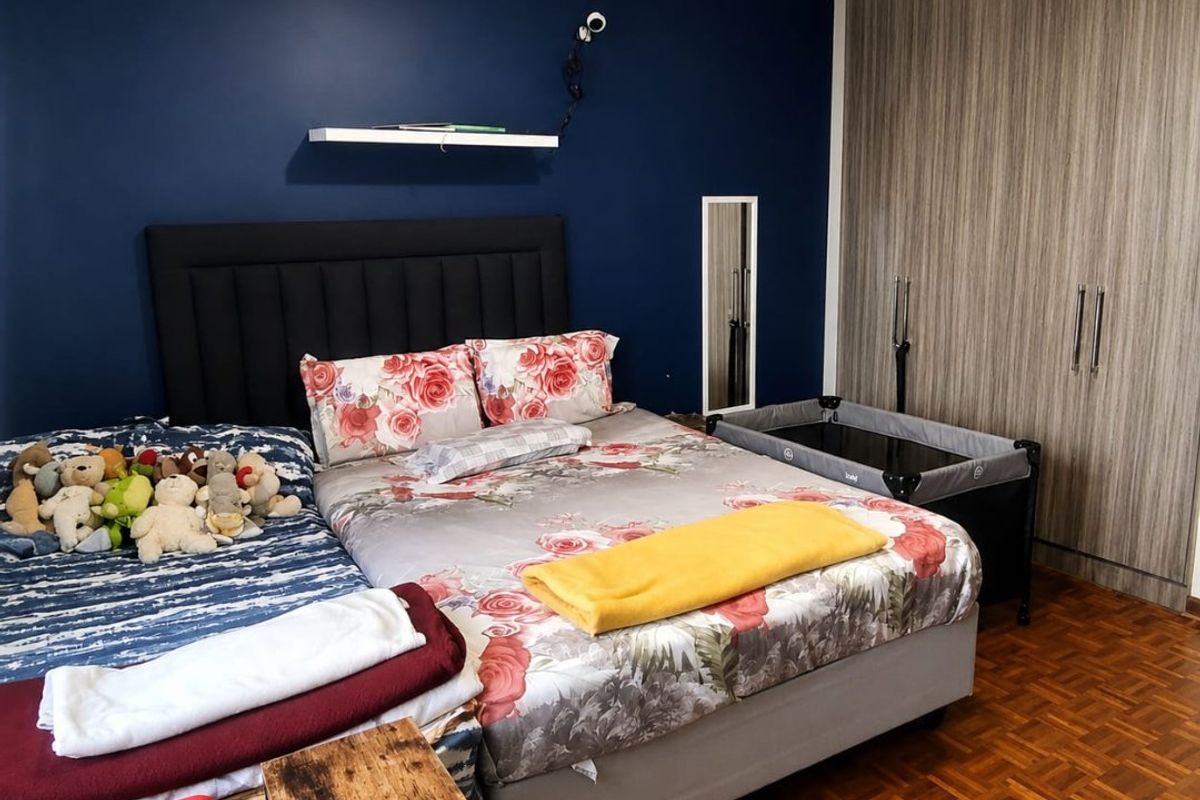 A bedroom featuring dark blue accent wall, built-in wooden cupboards, and classic parquet flooring.