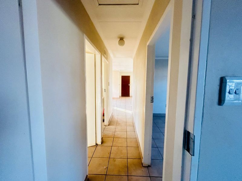 A functional, tiled hallway providing access to multiple rooms within the property, featuring neutral walls and standard internal door frames.