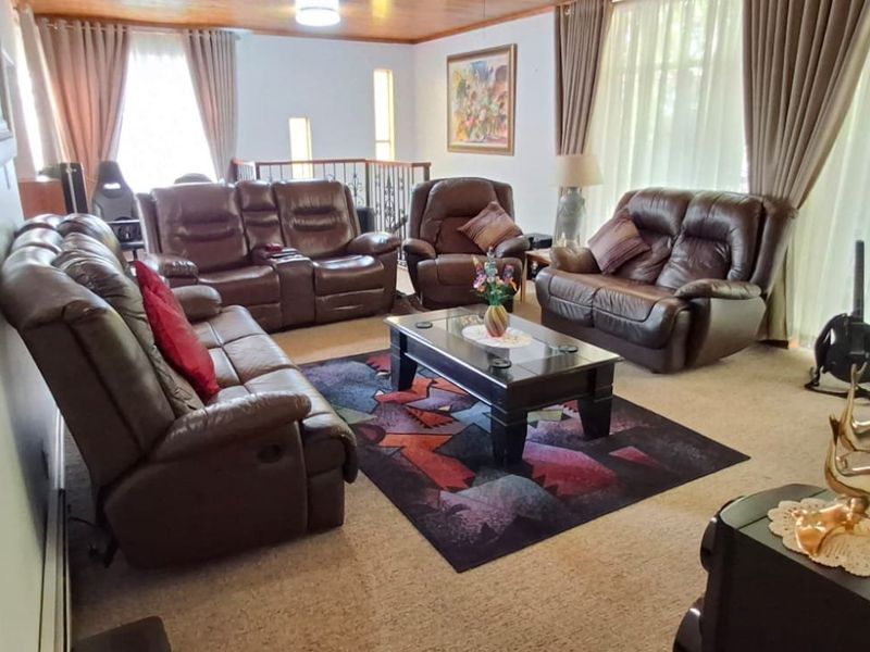 Spacious living room featuring a timber ceiling and an open staircase railing, providing a comfortable and functional family area.