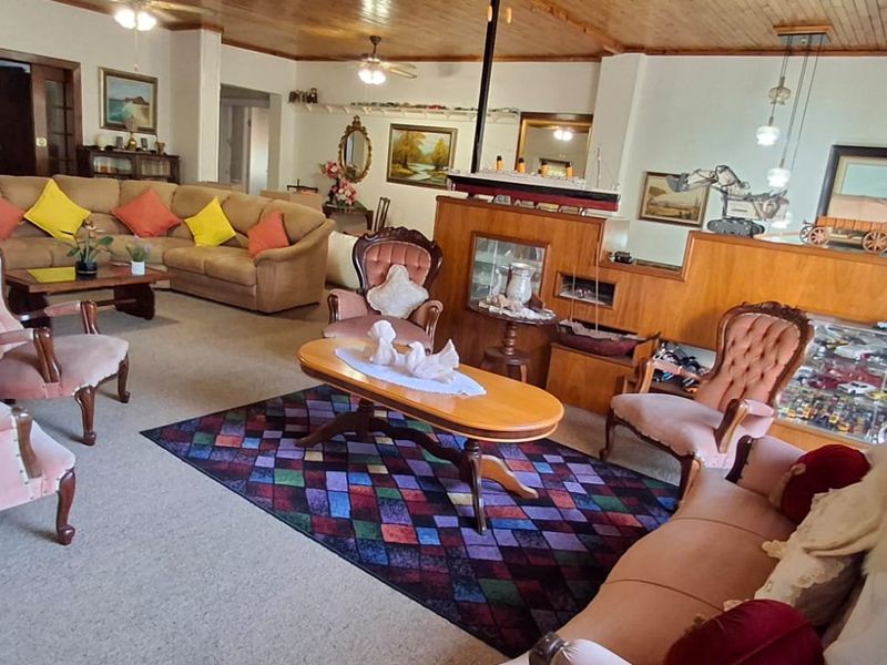Spacious living room featuring a timber-paneled ceiling, ceiling fans, and a built-in wooden room divider.