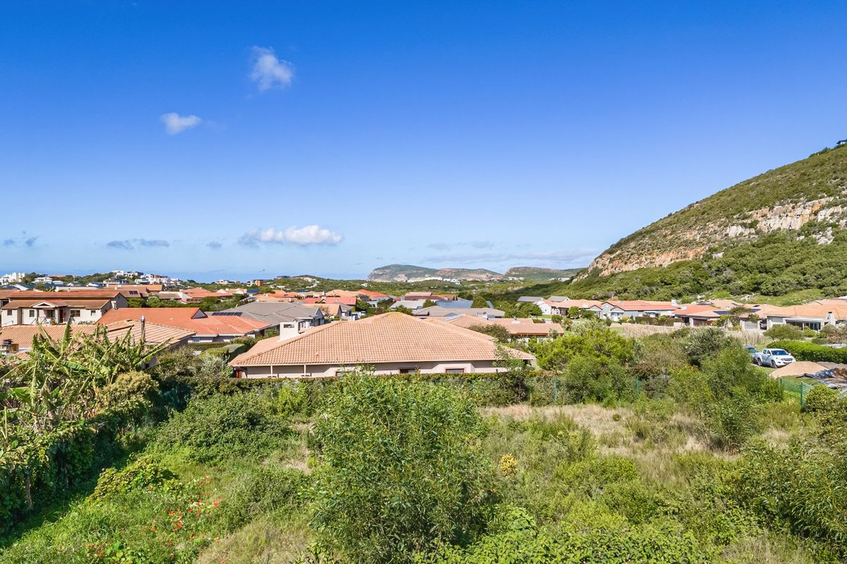 A scenic elevated view overlooking a residential neighbourhood with surrounding hills and natural landscape.