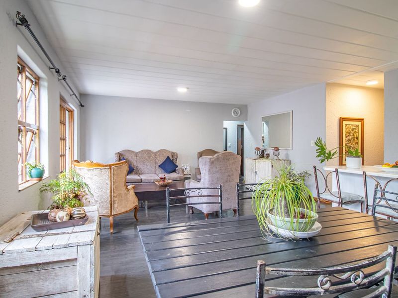 Spacious open-plan living and dining area featuring a functional kitchen with breakfast bar, neutral finishes, and ample natural light.