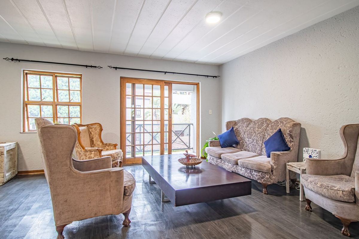 Spacious living room featuring textured walls, laminate flooring, and a sliding glass door providing access to an outdoor balcony area.