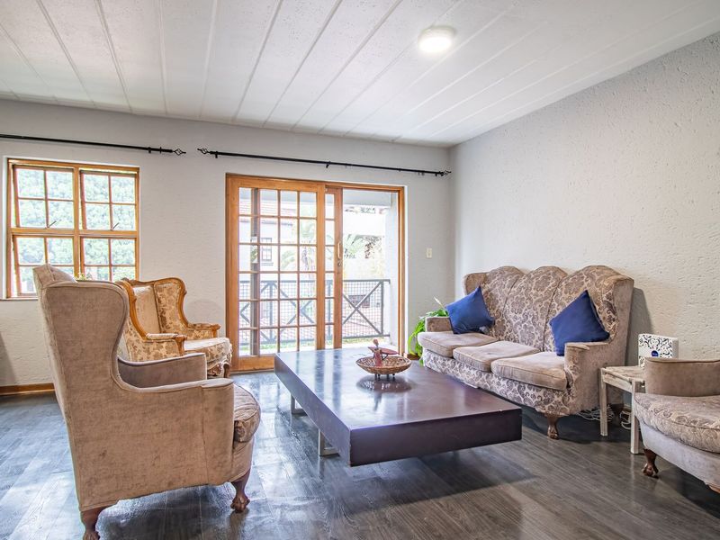 Spacious living room featuring textured walls, laminate flooring, and a sliding glass door providing access to an outdoor balcony area.