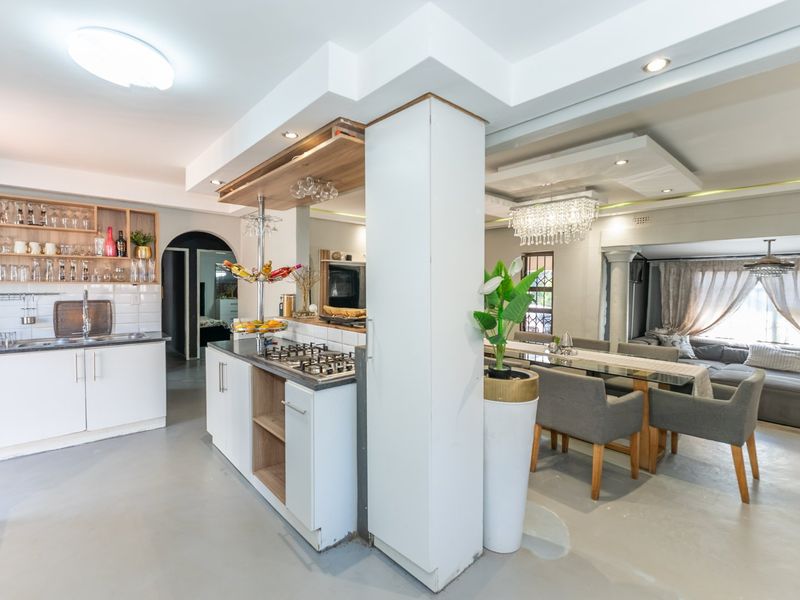 Spacious open-plan kitchen and dining area featuring modern cabinetry, a gas hob, and integrated lighting, creating a functional and cohesive living space.