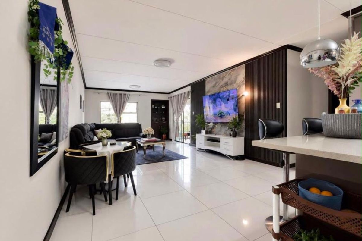 Modern open-plan living area featuring polished tiled floors, a striking slatted feature wall, and a breakfast bar connecting to the kitchen space.