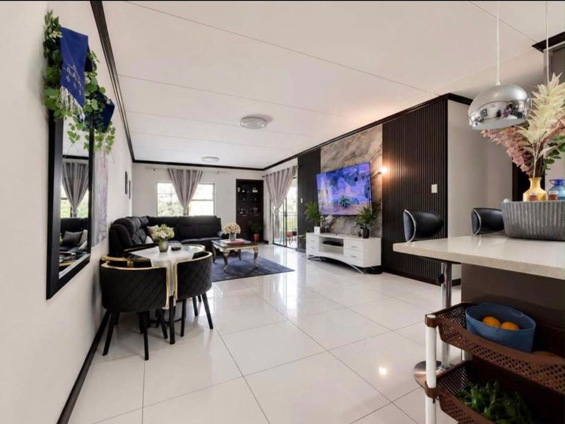 Modern open-plan living area featuring polished tiled floors, a striking slatted feature wall, and a breakfast bar connecting to the kitchen space.