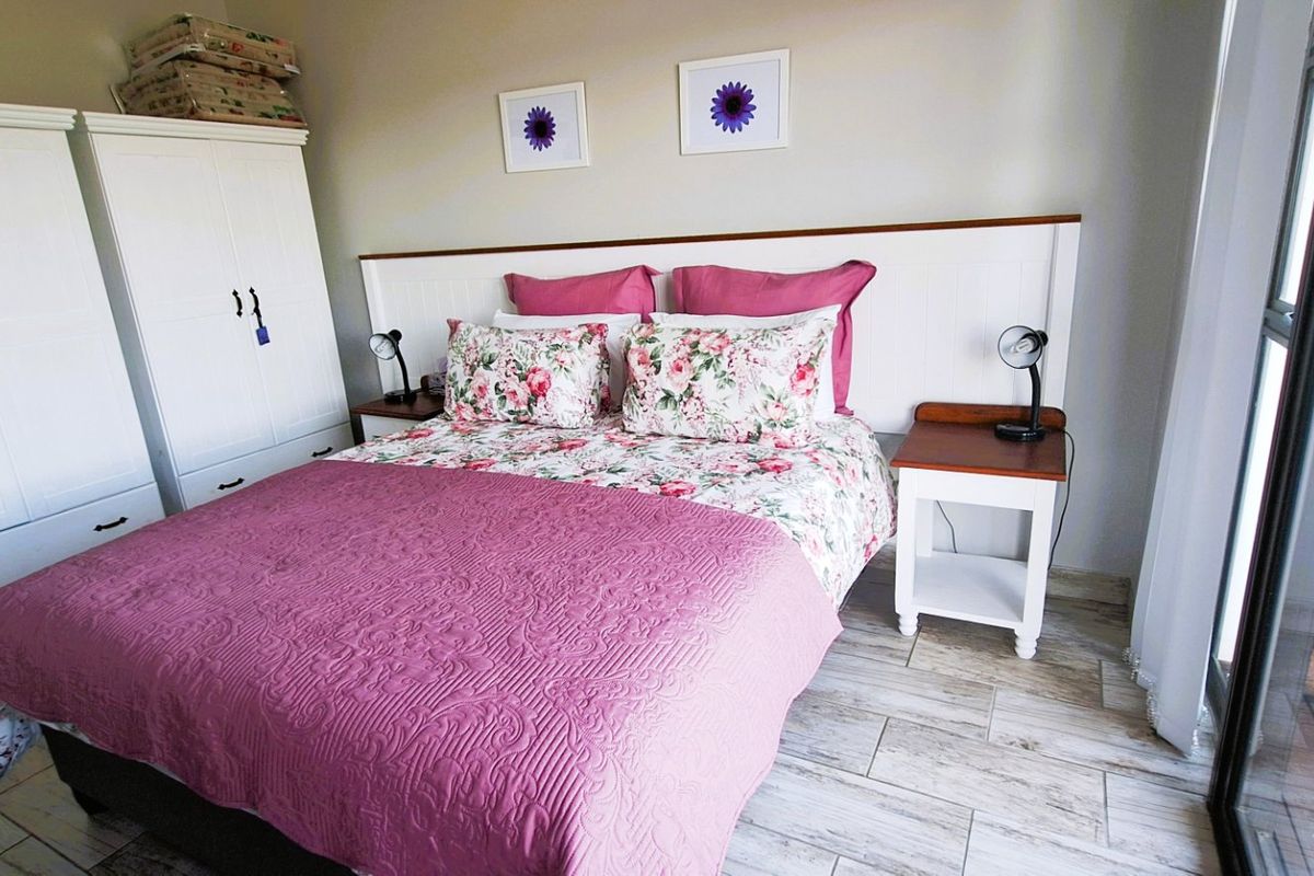 A well-lit bedroom featuring tiled flooring and a sliding glass door providing access to an outdoor area.