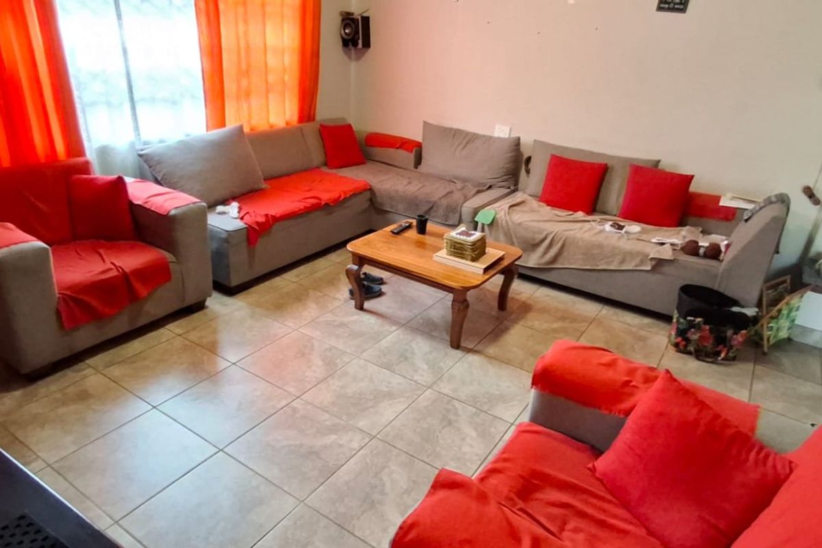 A living room featuring tiled flooring and a neutral wall finish, providing a functional space for relaxation.