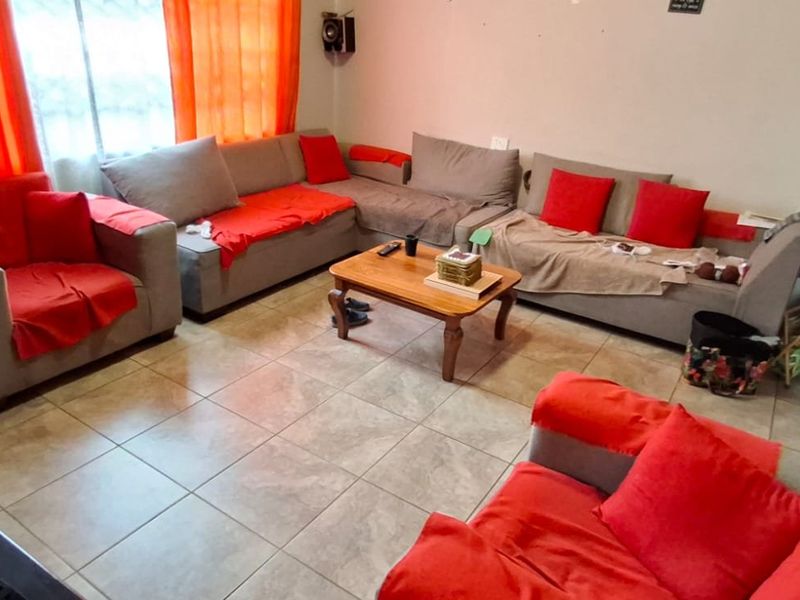 A living room featuring tiled flooring and a neutral wall finish, providing a functional space for relaxation.