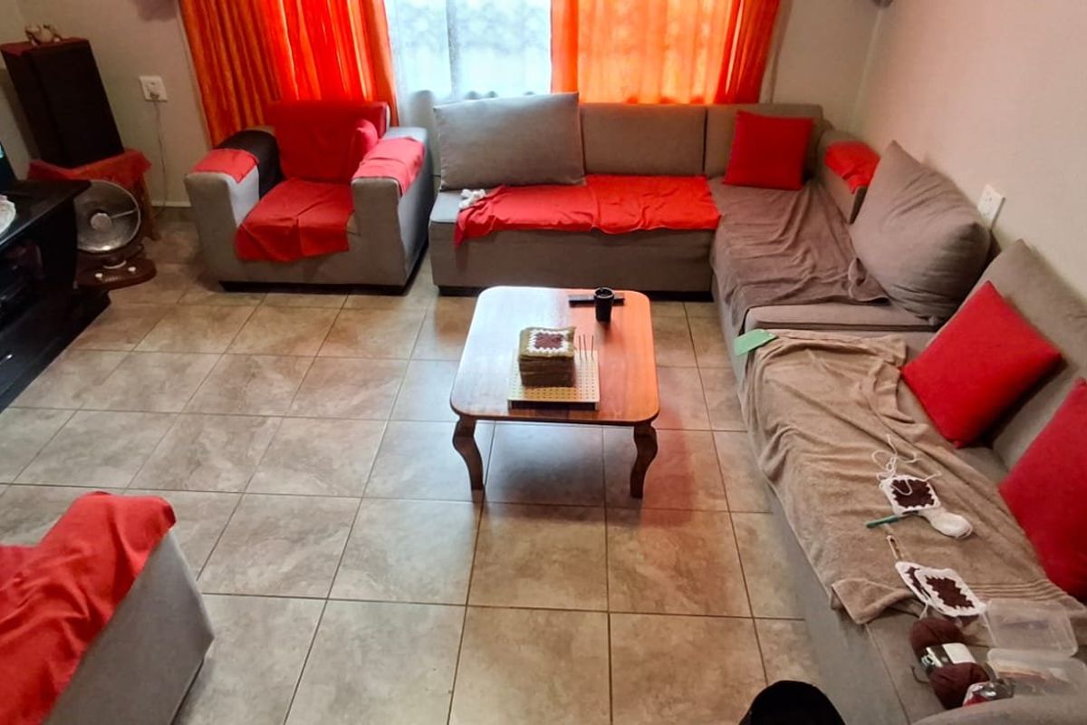 A living room featuring neutral ceramic floor tiles, providing a functional and durable base for the living space.