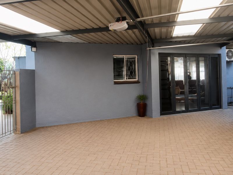 Spacious, well-maintained garage featuring paved flooring, a metal roof with integrated skylights, and secure access points to the main dwelling.