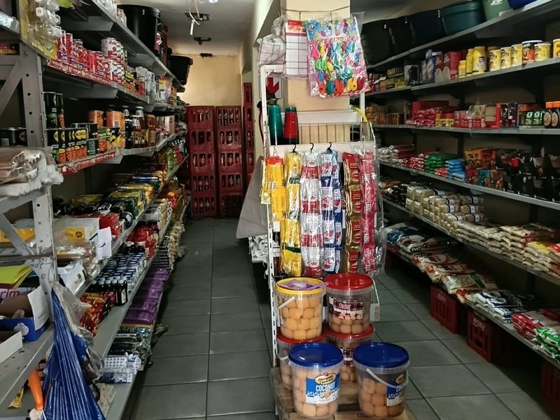 A commercial storage or utility space featuring metal shelving units and tiled flooring, currently used for inventory storage.
