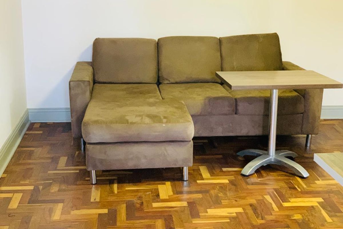 A living area featuring classic parquet timber flooring and neutral wall finishes.