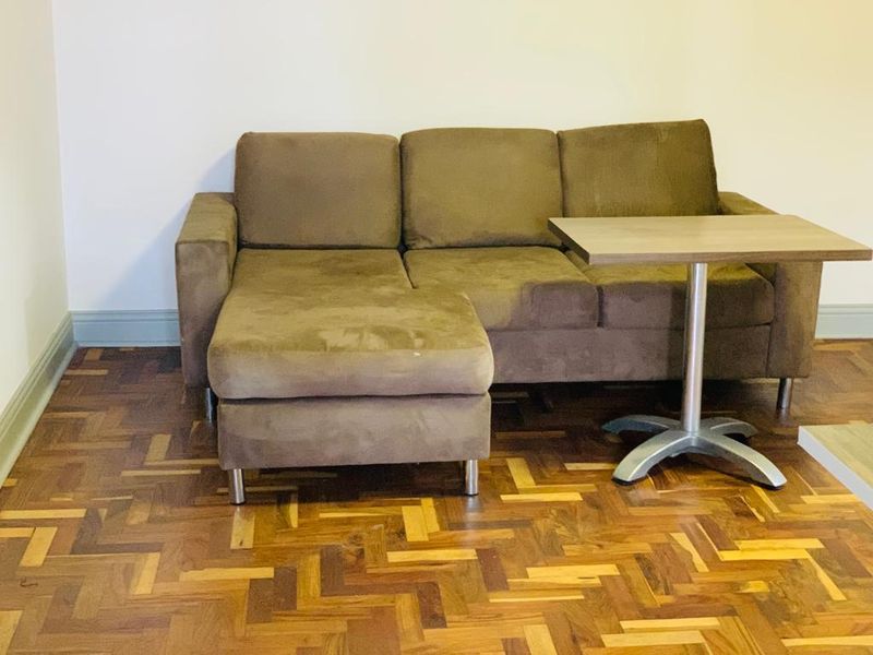 A living area featuring classic parquet timber flooring and neutral wall finishes.