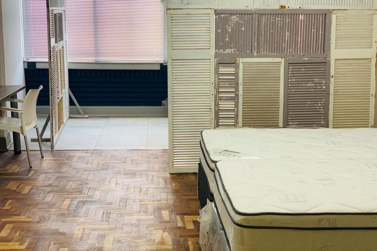 Bedroom featuring parquet flooring and a partitioned area with tiled floors and venetian blinds, requiring cosmetic updates to the wall finishes and flooring.