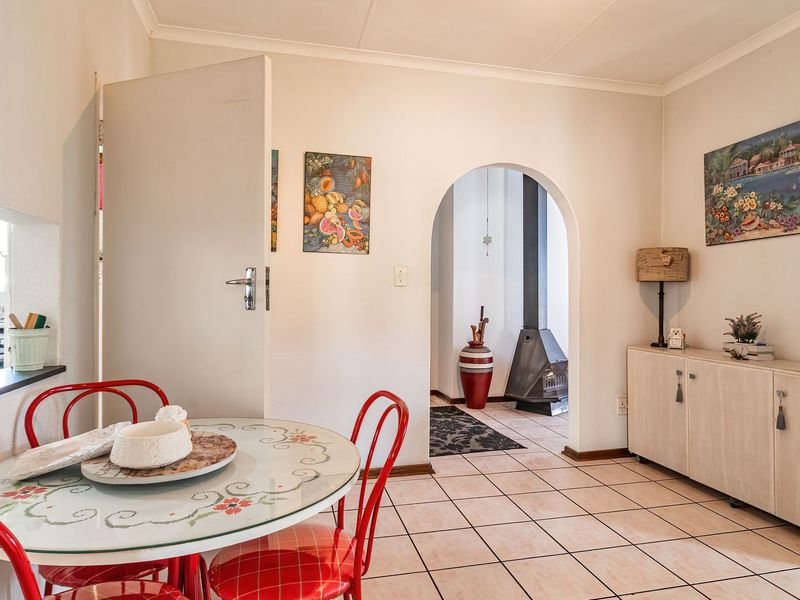 Dining area featuring tiled flooring and a distinctive arched doorway leading to a secondary space with a built-in fireplace.