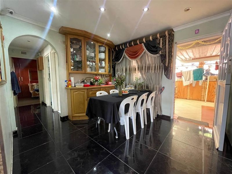 Dining area featuring dark tiled flooring, built-in cabinetry, and recessed lighting, providing a functional space with direct access to adjacent rooms.