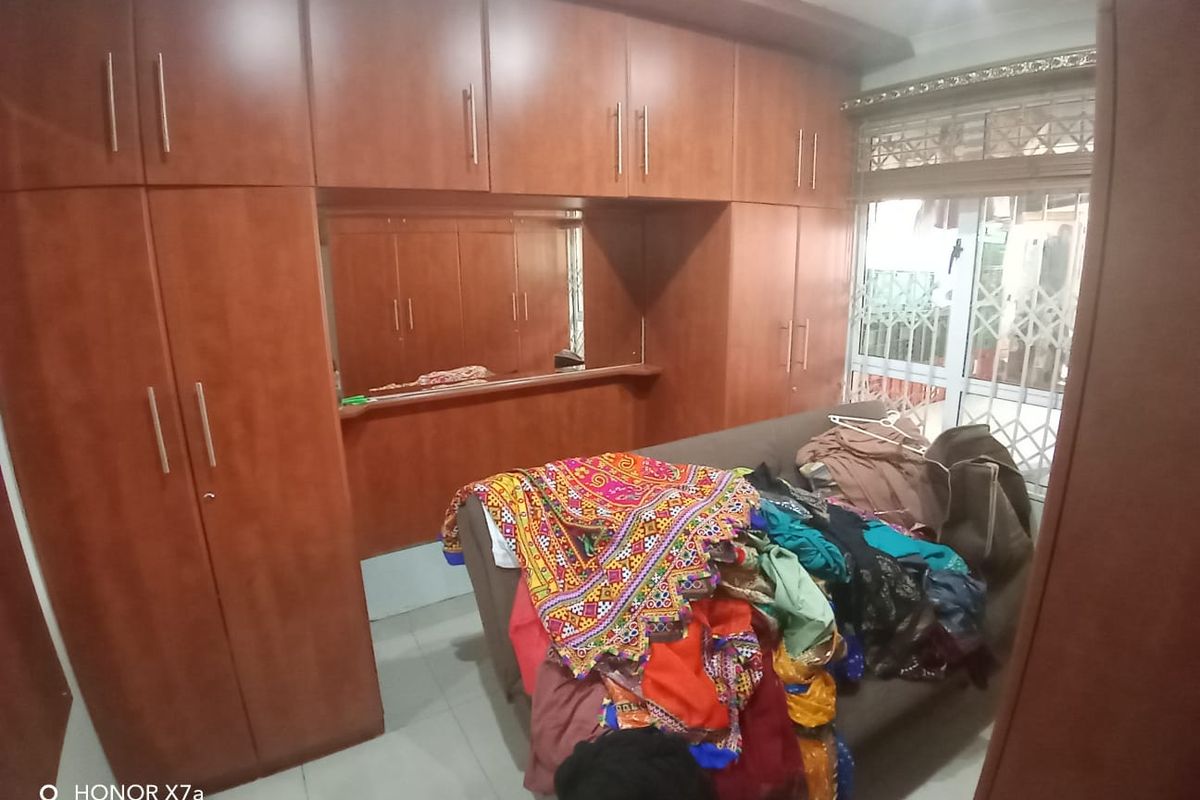 Bedroom featuring extensive built-in wooden cabinetry and a security gate leading to an outdoor area.