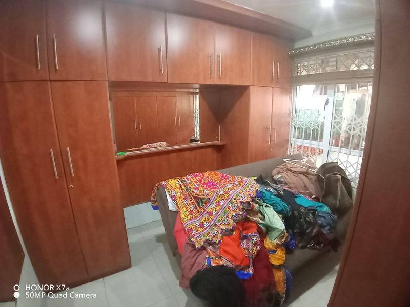 Bedroom featuring extensive built-in wooden cabinetry and a security gate leading to an outdoor area.
