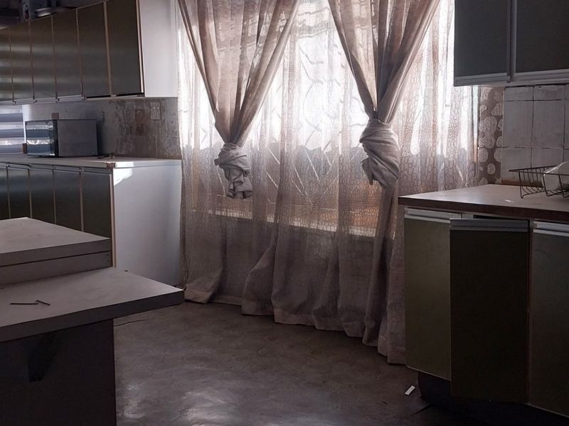 A dated kitchen featuring original built-in cabinetry and laminate countertops, requiring modernization to improve functionality and aesthetic appeal.