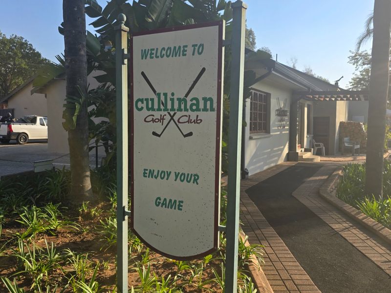 Exterior view of the Cullinan Golf Club entrance featuring a paved walkway, landscaped garden, and club signage.