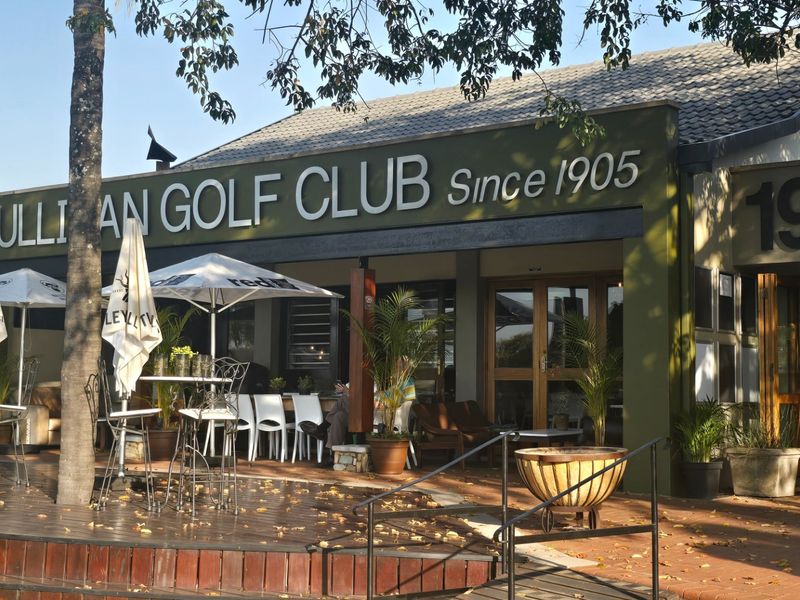 Exterior view of the Cullinan Golf Club entrance featuring a covered patio area with timber decking and brick paving.