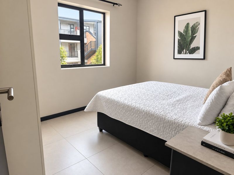 A well-maintained bedroom featuring neutral tiled flooring, a modern black aluminium window frame, and built-in storage.