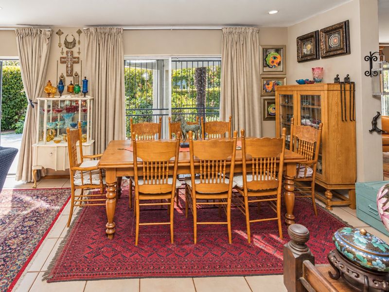A dining room featuring tiled flooring, recessed lighting, and sliding glass doors with security gates providing access to the outdoor area.