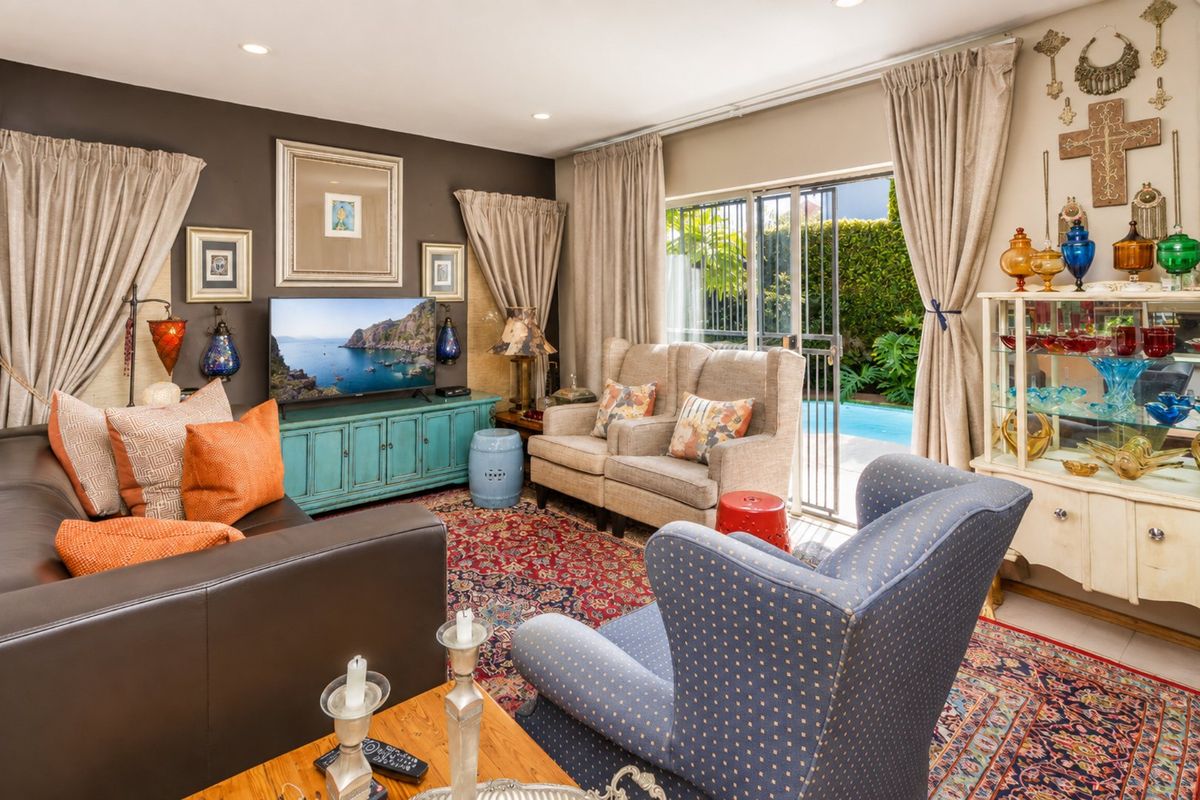 A comfortable living room featuring recessed lighting and a sliding glass door providing direct access to the outdoor pool area.