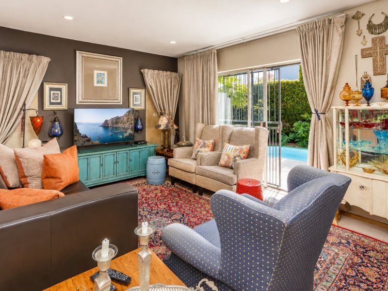A comfortable living room featuring recessed lighting and a sliding glass door providing direct access to the outdoor pool area.