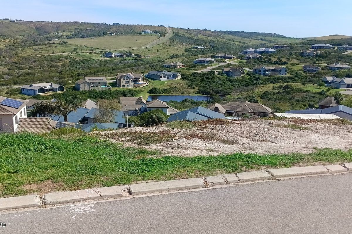 An elevated view overlooking a residential estate with rolling hills and natural landscape in the background.