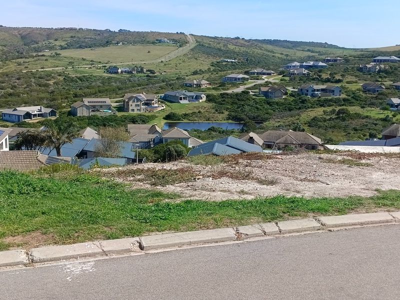An elevated view overlooking a residential estate with rolling hills and natural landscape in the background.